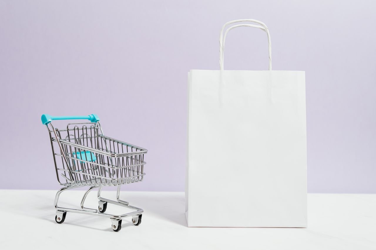 Flat lay of product packaging and a laptop showing an online store