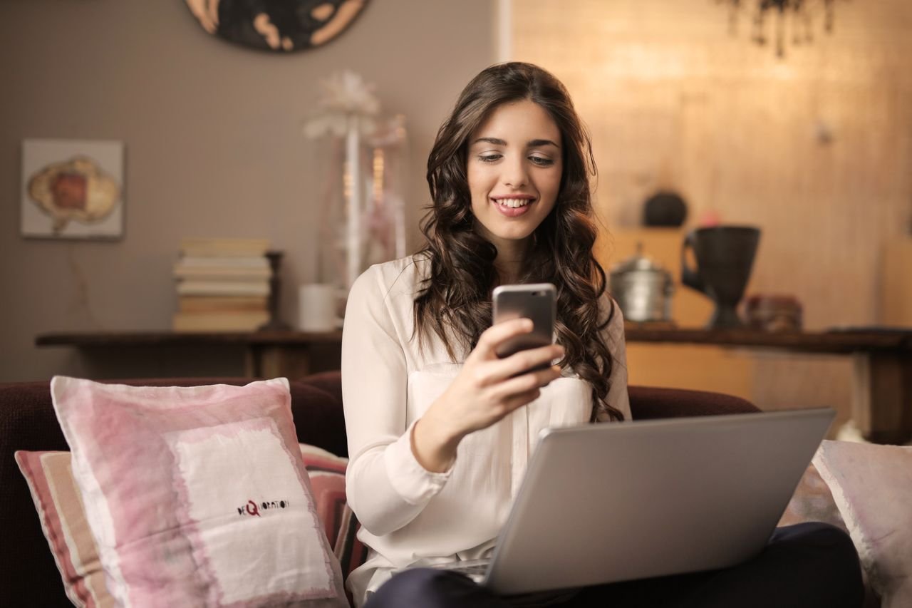 Person analyzing website ranking data on a laptop and notepad
